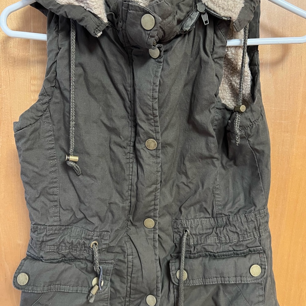 YMI warm, lined vest in olive green. This offers both zip and snap closure.